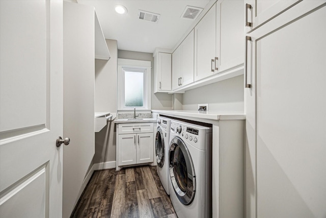 1111 Adele St, Houston, TX 77009 - washroom with separate washer and dryer, dark wood finished floors, cabinet space, and visible vents