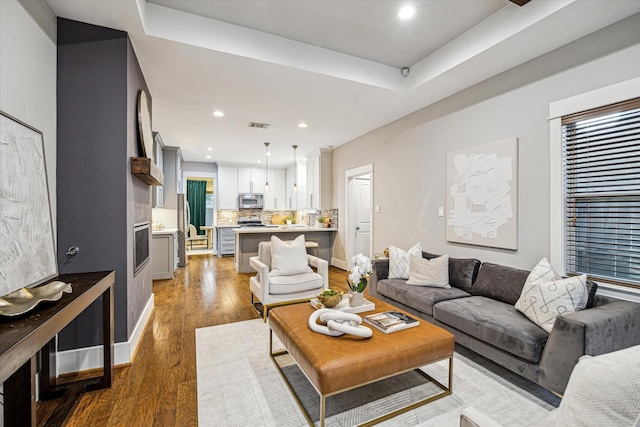 1111 Adele St, Houston, TX 77009 - living area with visible vents, wood finished floors, baseboards, recessed lighting, and a tray ceiling