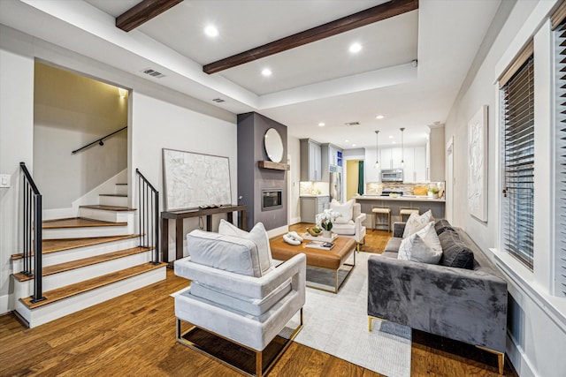 1111 Adele St, Houston, TX 77009 - living area featuring beamed ceiling, visible vents, wood finished floors, and stairway