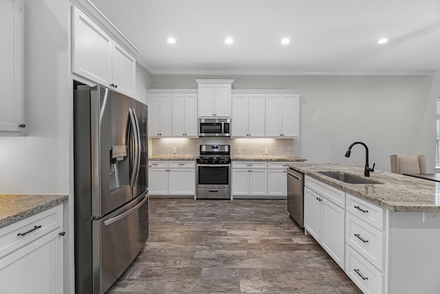 kitchen featuring stainless steel appliances, backsplash, crown molding, and a sink