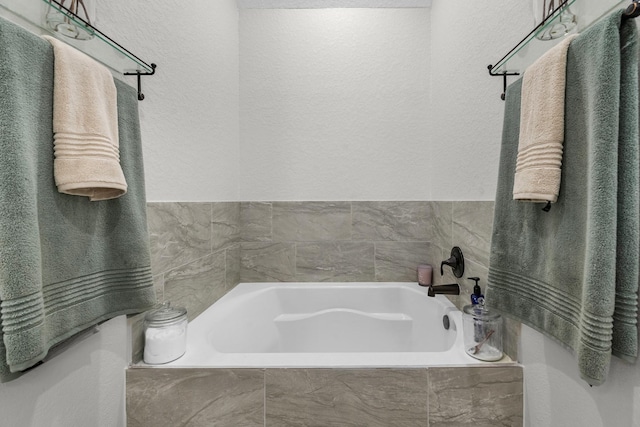 full bathroom featuring a bath and a textured wall
