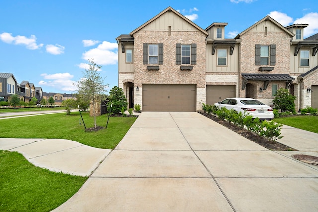 townhome / multi-family property with board and batten siding, a front yard, a garage, brick siding, and concrete driveway