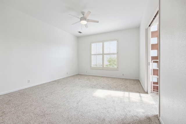 unfurnished room with ceiling fan, baseboards, and carpet