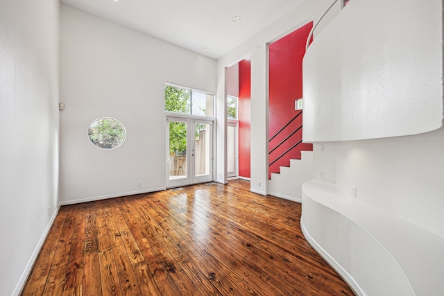 entrance foyer with baseboards, hardwood / wood-style flooring, and stairway