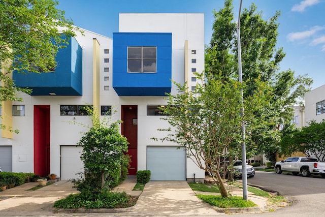 view of front facade featuring a garage, stucco siding, and driveway