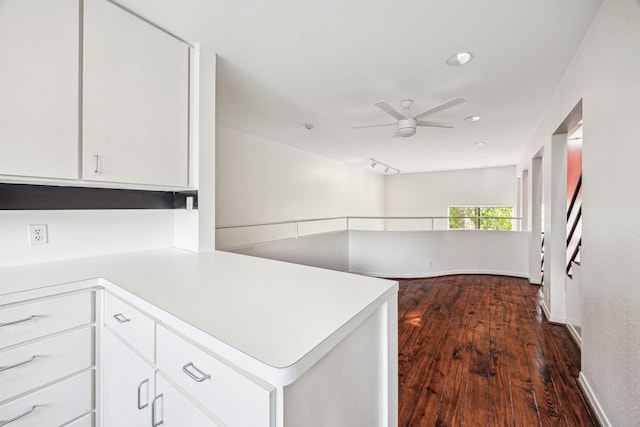 kitchen featuring light countertops, a ceiling fan, a peninsula, and white cabinetry