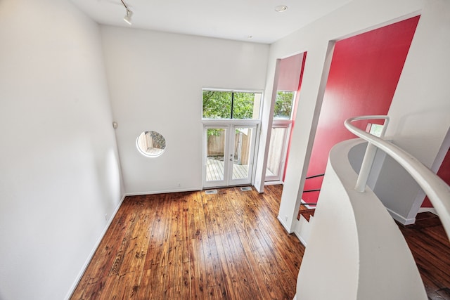 interior space with wood-type flooring, baseboards, visible vents, and french doors