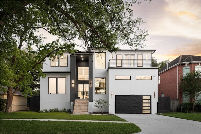 5008 Holt St, Bellaire, TX 77401 - modern home with concrete driveway, a balcony, an attached garage, fence, and a front lawn