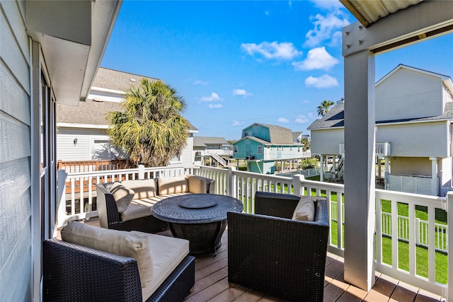 view of wooden balcony with a deck, outdoor lounge area, and a residential view