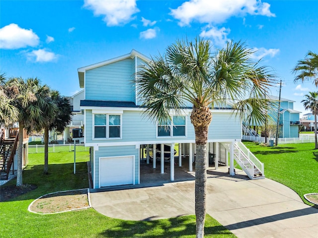 coastal inspired home with stairway, a carport, concrete driveway, and a front lawn