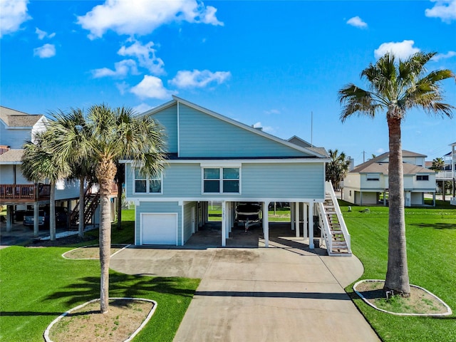 rear view of house with a garage, a yard, stairs, a carport, and concrete driveway