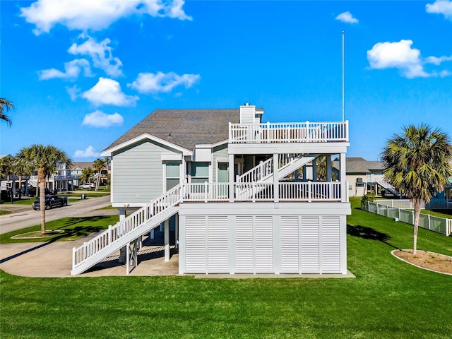 rear view of house with a wooden deck, stairway, a patio area, a yard, and fence