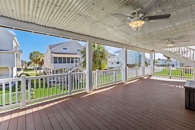 wooden terrace featuring a residential view, ceiling fan, and stairway