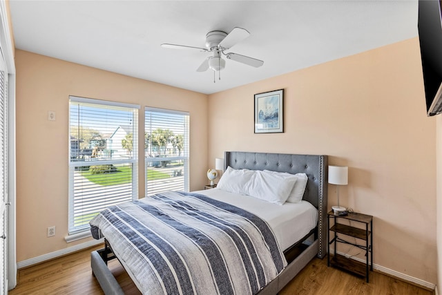 bedroom featuring ceiling fan, wood finished floors, and baseboards