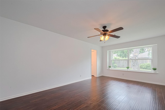 unfurnished room featuring dark wood-type flooring, ceiling fan, and baseboards