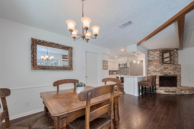 dining area featuring a chandelier, dark wood-style flooring, baseboards, visible vents, and a textured ceiling