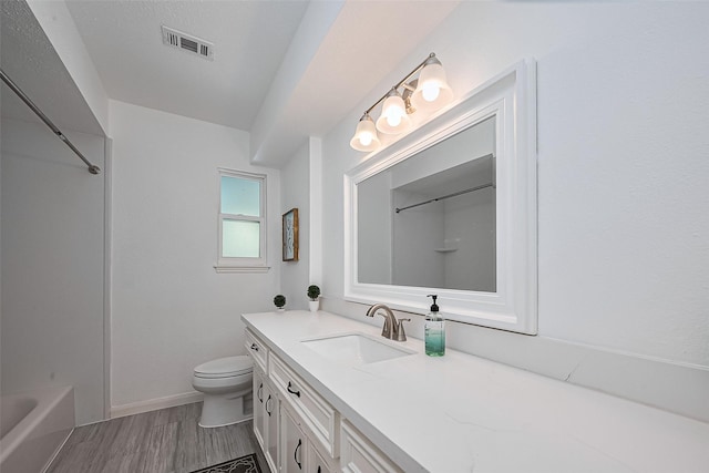 bathroom featuring washtub / shower combination, vanity, toilet, visible vents, and wood finished floors