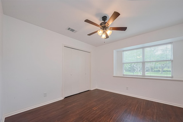 unfurnished bedroom with visible vents, ceiling fan, a closet, baseboards, and dark wood-type flooring