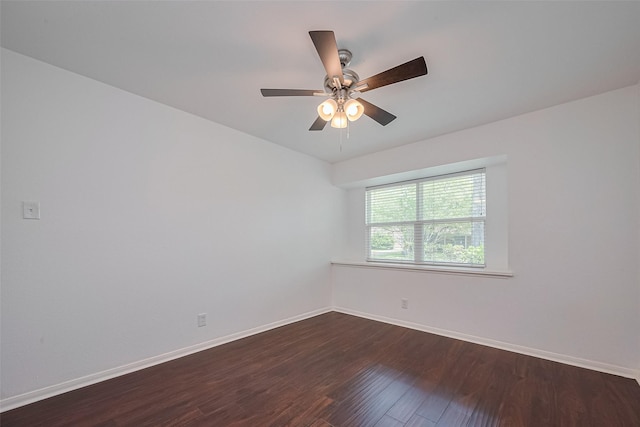 empty room featuring a ceiling fan, baseboards, and dark wood finished floors
