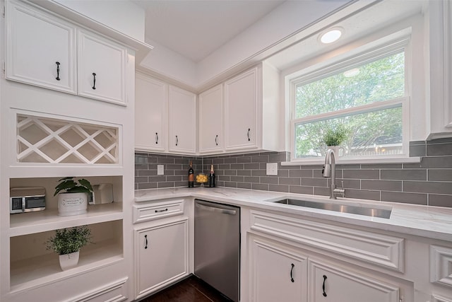 kitchen with a sink, tasteful backsplash, light stone counters, stainless steel dishwasher, and white cabinets
