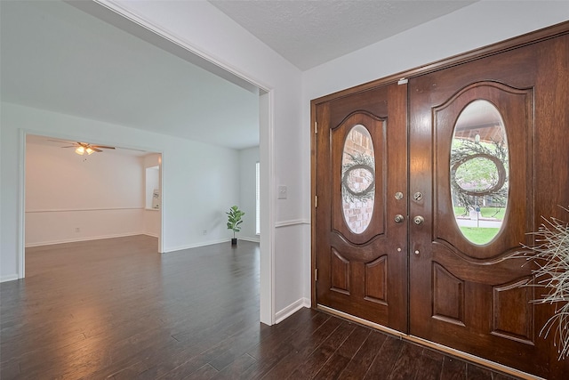 foyer with dark wood-style flooring, ceiling fan, and baseboards