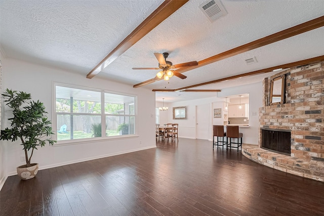 living area featuring a textured ceiling, visible vents, and beamed ceiling