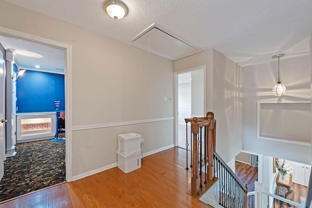 8310 Mentmore Dr, Spring, TX 77379 - hall with attic access, an upstairs landing, wood finished floors, a textured ceiling, and baseboards