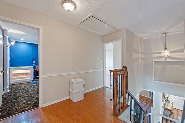 8310 Mentmore Dr, Spring, TX 77379 - hallway featuring attic access, an upstairs landing, wood finished floors, baseboards, and a textured ceiling