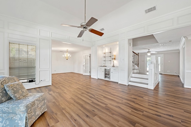8310 Mentmore Dr, Spring, TX 77379 - living room with ceiling fan, ornamental molding, dark wood-style flooring, a chandelier, and a decorative wall