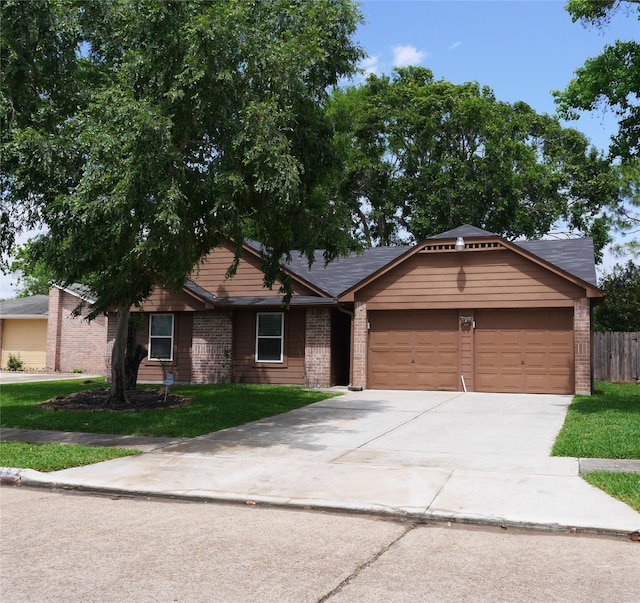 view of front facade featuring a garage, a front yard, driveway, and brick siding