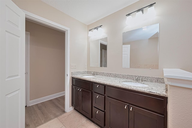bathroom featuring tile patterned flooring, double vanity, and a sink