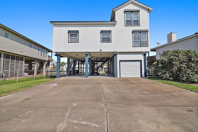 beach home with a carport, concrete driveway, stairs, and an attached garage