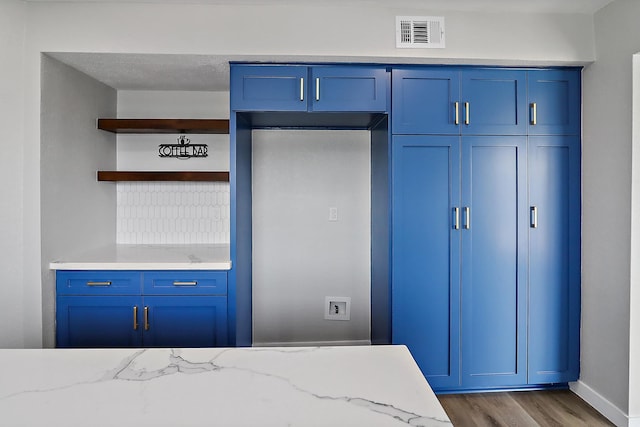 bedroom featuring baseboards, visible vents, wood finished floors, and a closet