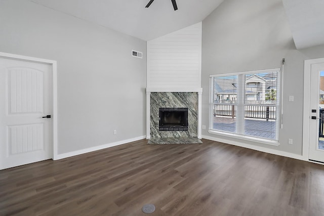 unfurnished living room with visible vents, a premium fireplace, wood finished floors, a ceiling fan, and high vaulted ceiling