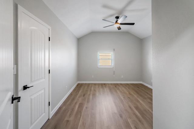 unfurnished room featuring lofted ceiling, wood finished floors, ceiling fan, and baseboards