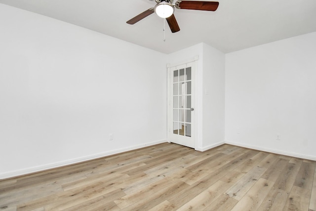 spare room with baseboards, ceiling fan, and light wood-style floors