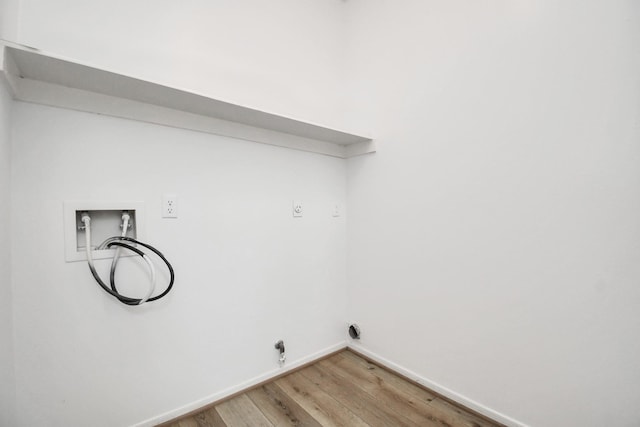 washroom with hookup for a washing machine, light wood-style floors, laundry area, and baseboards