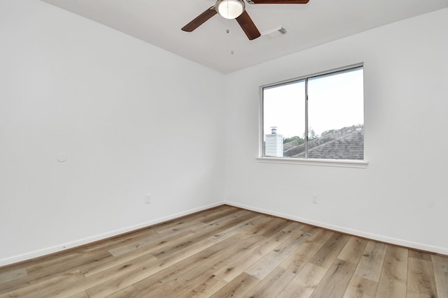 unfurnished room with a ceiling fan, visible vents, light wood-style flooring, and baseboards