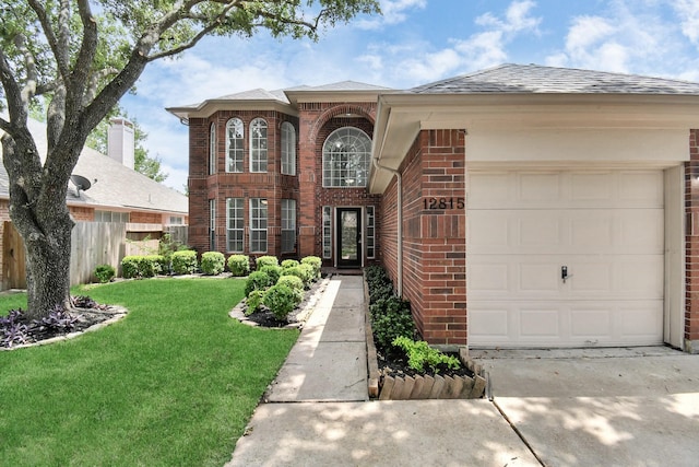 view of exterior entry with a yard, brick siding, fence, driveway, and an attached garage