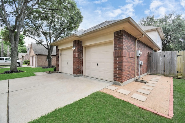 view of property exterior featuring a gate, driveway, brick siding, an attached garage, and fence