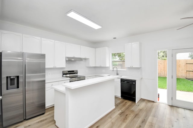kitchen featuring tasteful backsplash, stainless steel appliances, under cabinet range hood, and light countertops