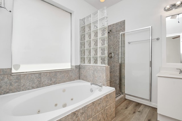 full bathroom with a tub with jets, vanity, a shower stall, and wood finished floors