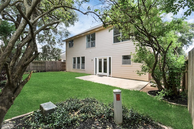 back of property with a lawn, a fenced backyard, and a patio area