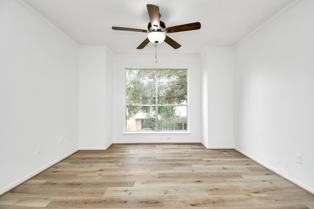 empty room with wood finished floors, a ceiling fan, ornamental molding, and baseboards