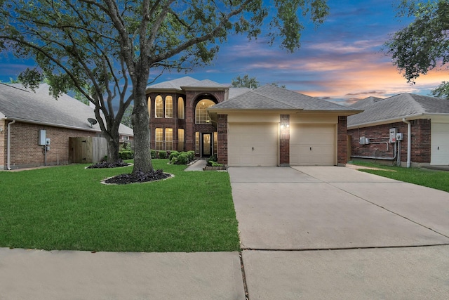 view of front of home with a garage, brick siding, a front yard, and concrete driveway