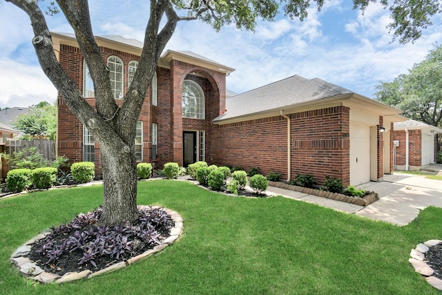 traditional-style home with brick siding, fence, a front lawn, and an attached garage