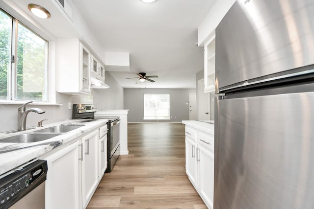 2207 Bauer Dr Unit A, Houston, TX 77080 - kitchen with stainless steel appliances, a sink, light countertops, ceiling fan, and white cabinets