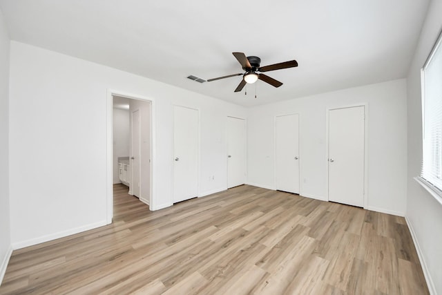 2207 Bauer Dr Unit A, Houston, TX 77080 - unfurnished bedroom with two closets, light wood-style floors, baseboards, and a ceiling fan