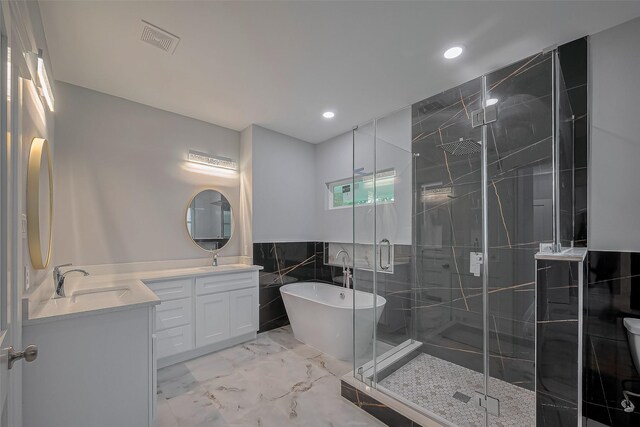 403 Smith St, Dayton, TX 77535 - bathroom featuring marble tiled floors, double vanity, a freestanding bath, a shower stall, and recessed lighting