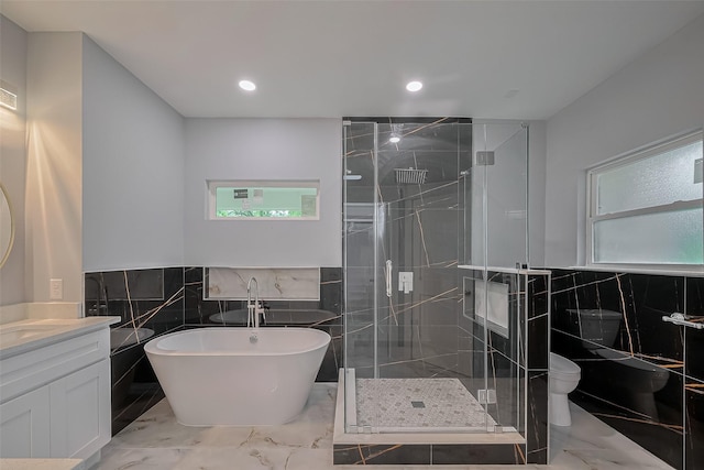 403 Smith St, Dayton, TX 77535 - full bathroom featuring marble finish floor, a shower stall, a soaking tub, and tile walls